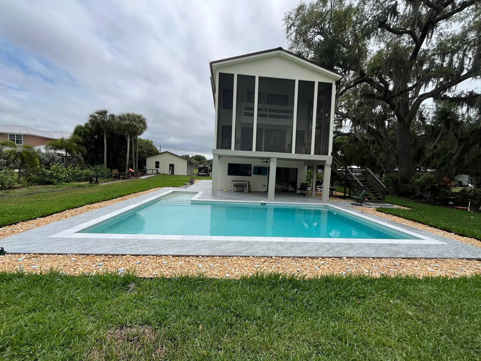 Before — two-story Florida home with pool before custom pool cage installation