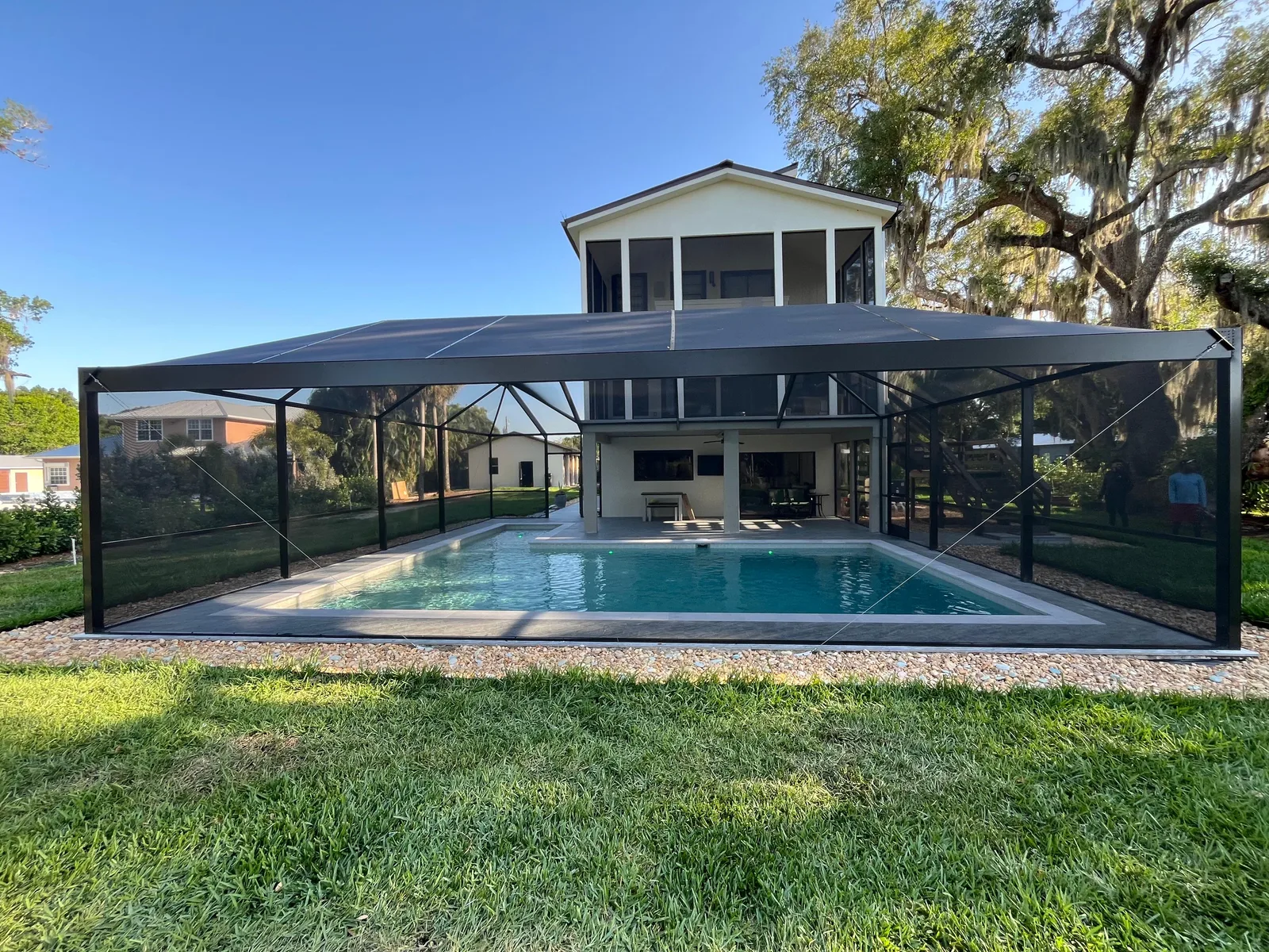 After — same two-story Florida home with custom aluminum pool cage now installed
