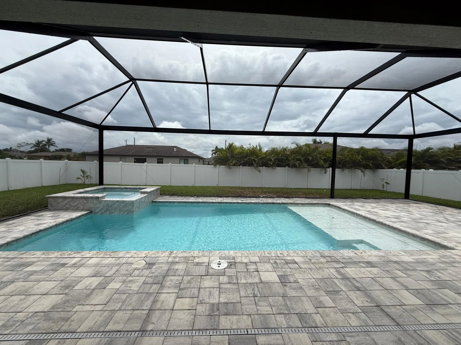 Pool and hot tub inside new aluminum pool cage with travertine paver surround, Southwest Florida