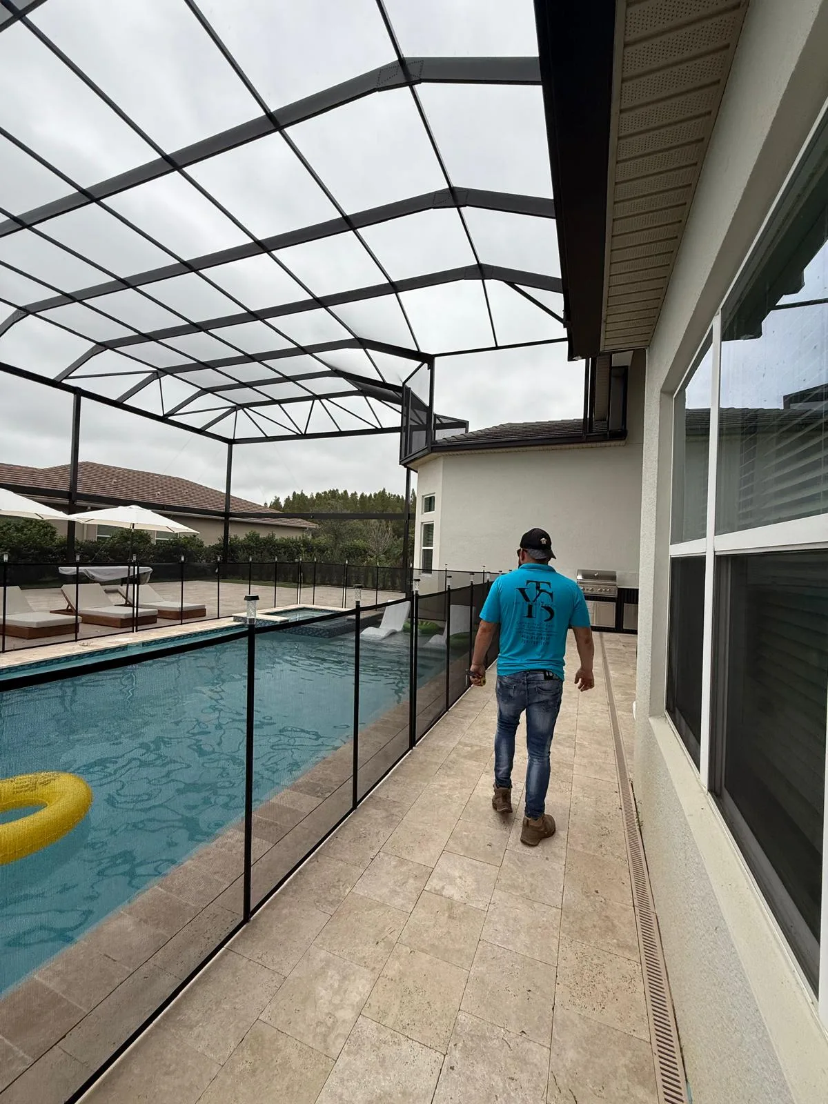 Yasma Screen crew member inside pool cage wearing The Yasma Screen shirt, Southwest Florida