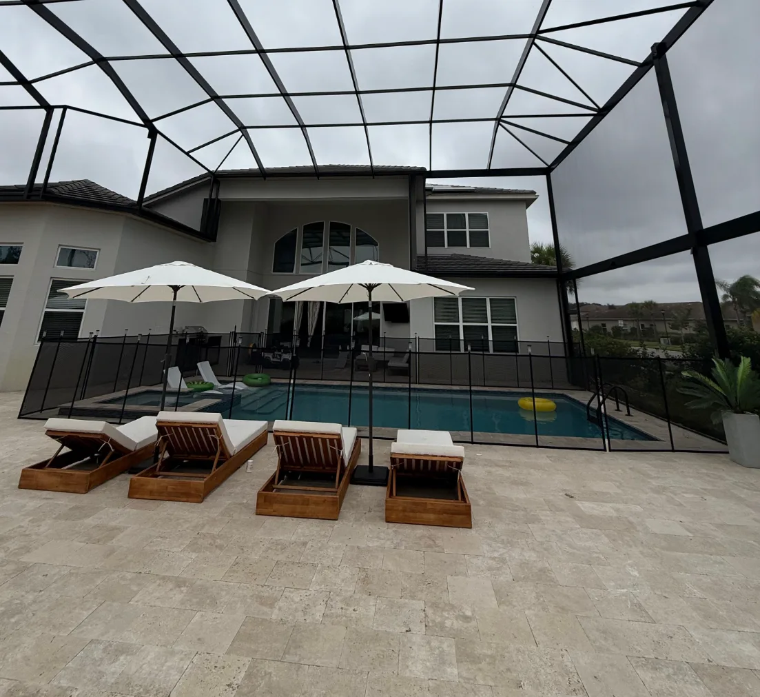 Custom pool cage with lounge chairs and umbrellas on Florida pool deck
