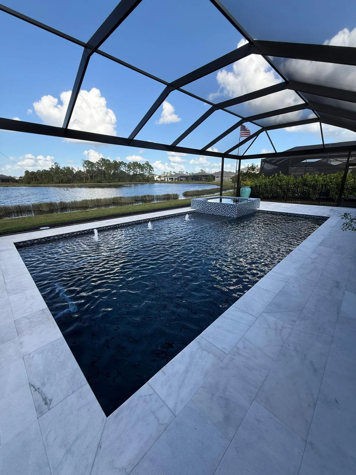 Custom aluminum pool cage with fountain and waterfront view in Southwest Florida