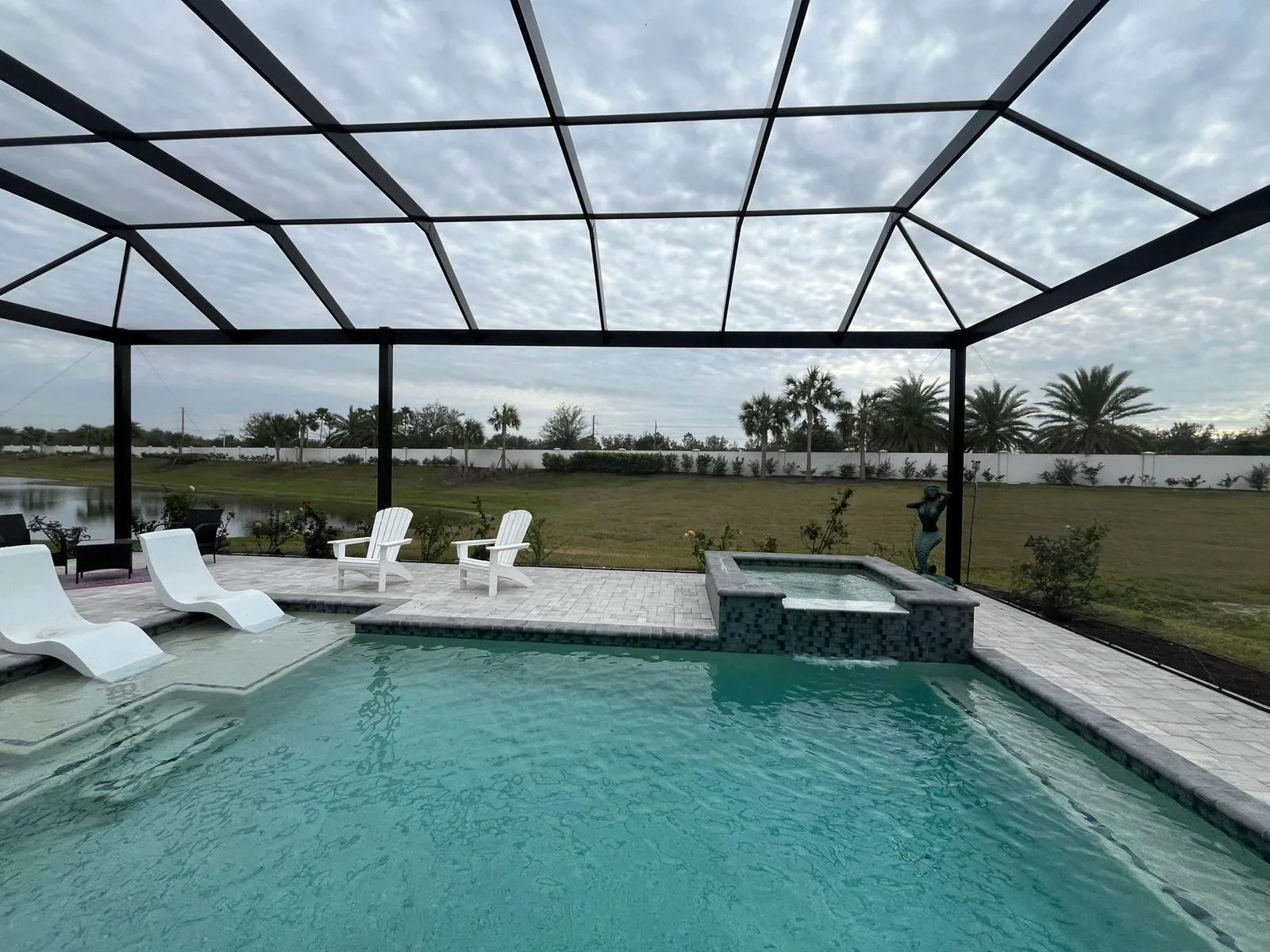 Pool cage enclosure with lounge chairs and palm trees, Southwest Florida