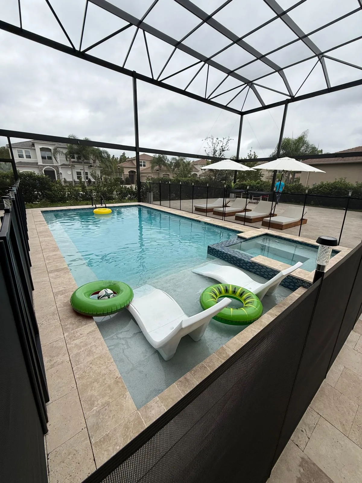 Pool cage enclosure with colorful pool floats and tropical backyard, Florida